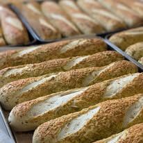 Scored baguettes on a baking tray