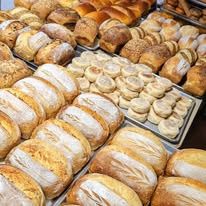 Racks full of fresh loaves, buns and bagels