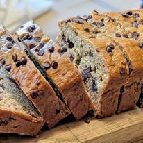 A sliced chocolate chip loaf on a wooden board