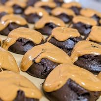 Chocolate cookies topped with peanut butter on a baking tray