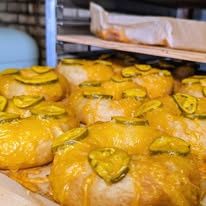 Glazed pastries topped with sliced fruit on baking trays