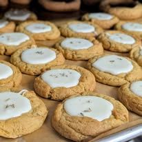 Soft cookies with white icing on a baking tray