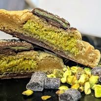 A cookie cut open to show a green pistachio filling