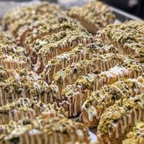 Rows of glazed bakes sprinkled with pistachio crumble