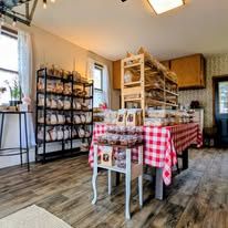 Inside our garage shop: bread shelves and a table with a red gingham cloth