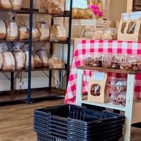 Shelves of bread and a gingham-covered table in our shop