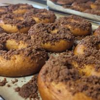 Bagels with a cinnamon streusel topping on a baking tray